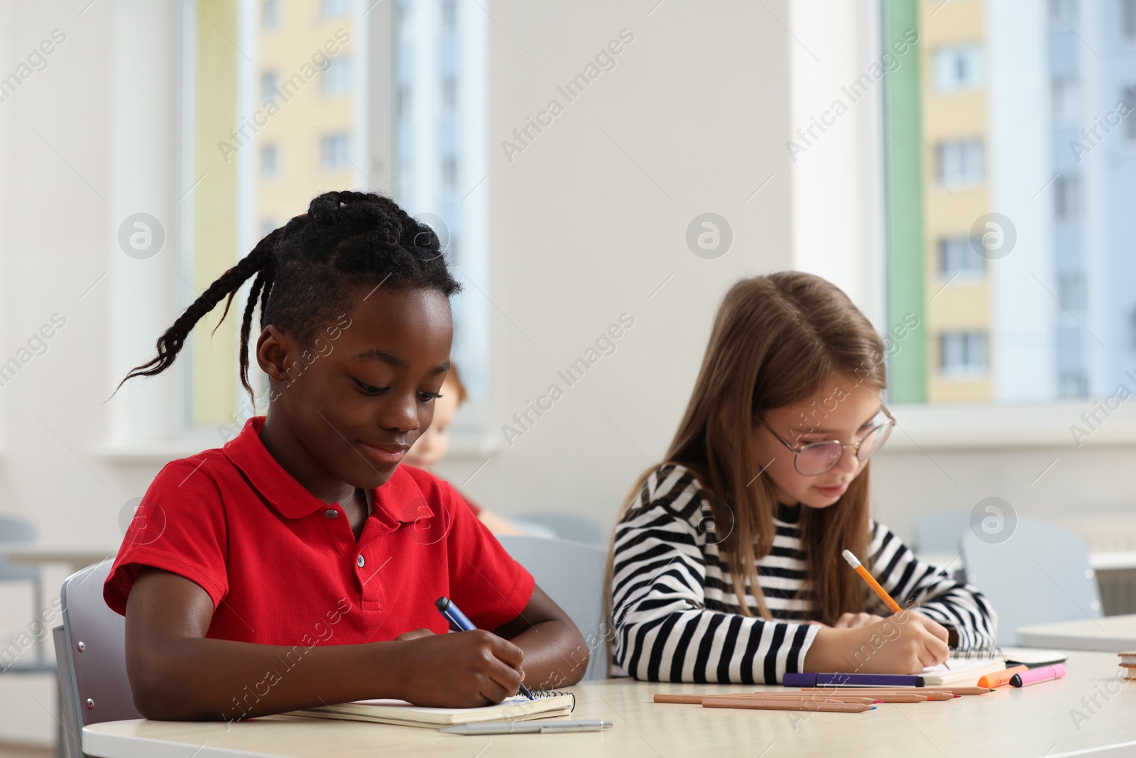 Photo of Cute children studying in classroom at school