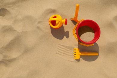 Set of plastic beach toys on sand, flat lay. Outdoor play