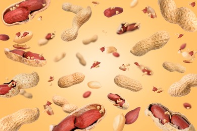 Image of Unpeeled peanuts in air on beige background