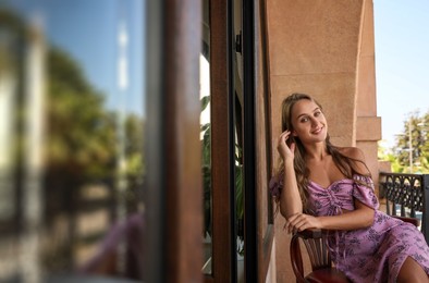 Photo of Beautiful young woman enjoying her time on balcony