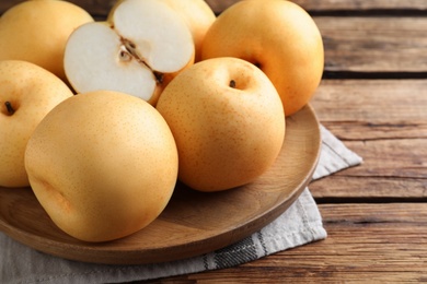 Photo of Cut and whole apple pears on wooden table, closeup