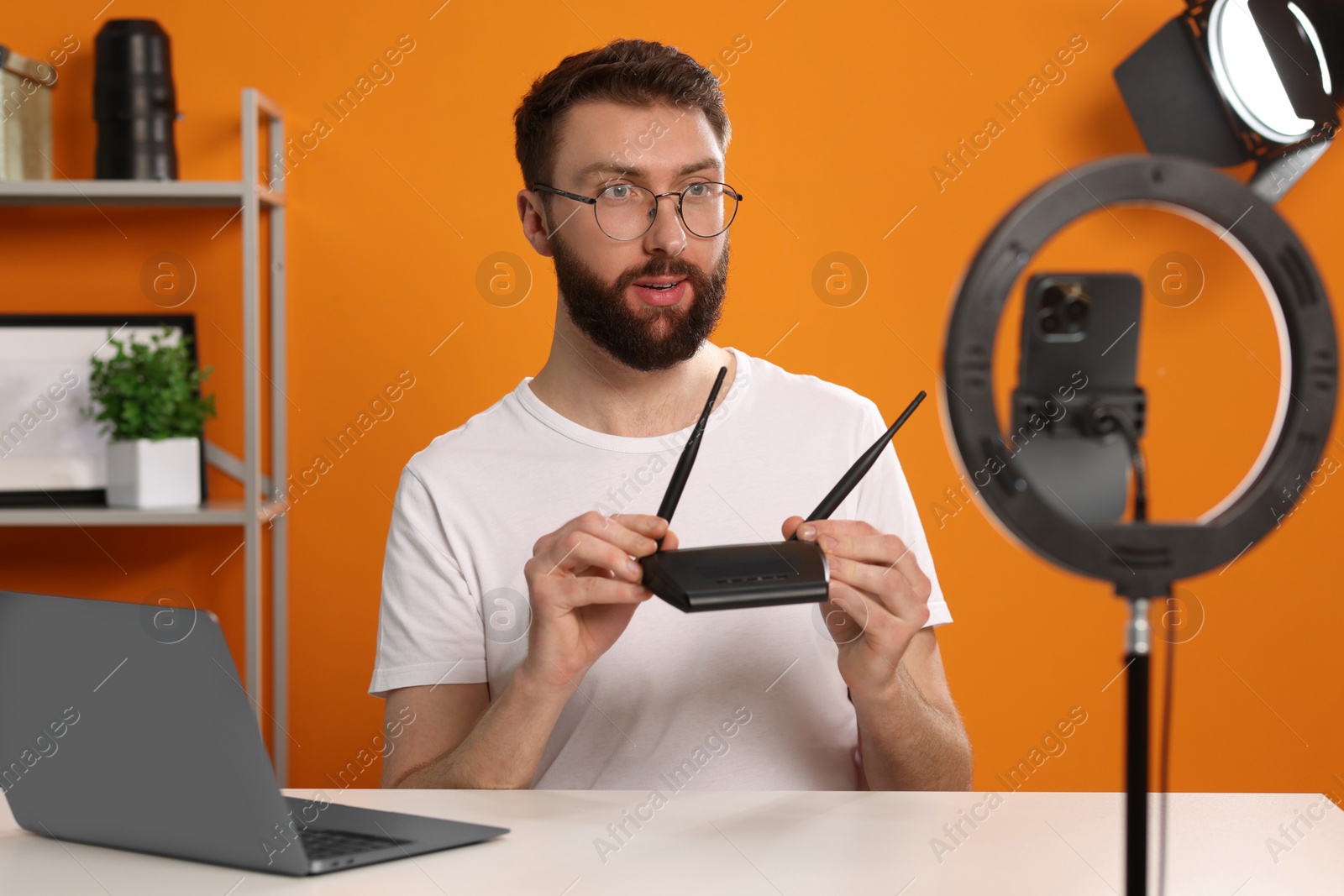 Photo of Technology blogger recording video review about WI-FI router at home