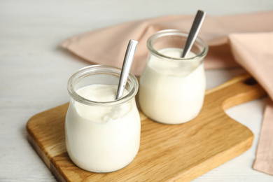 Photo of Tasty organic yogurt on white wooden table