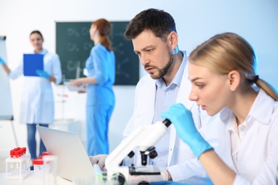 Group of scientists working in modern chemistry laboratory