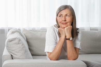 Portrait of beautiful senior woman on sofa at home