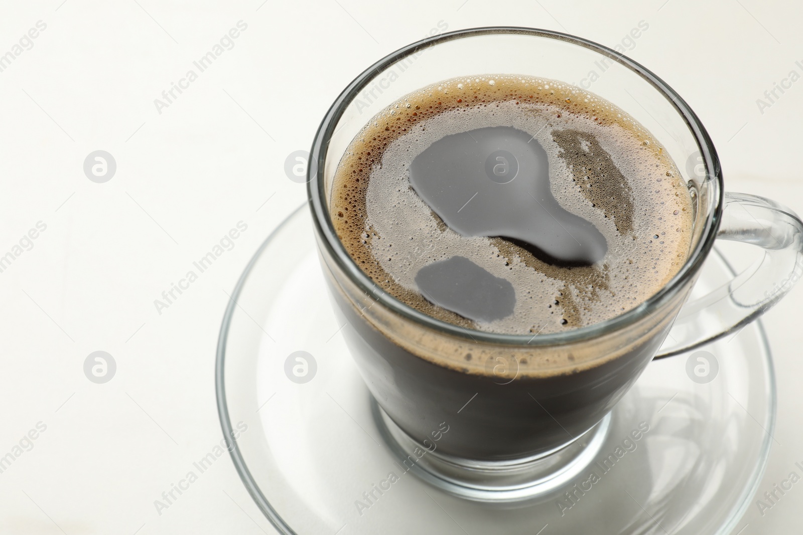 Photo of Cup of aromatic coffee on white table, closeup. Space for text