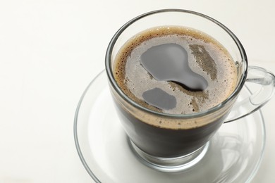 Photo of Cup of aromatic coffee on white table, closeup. Space for text