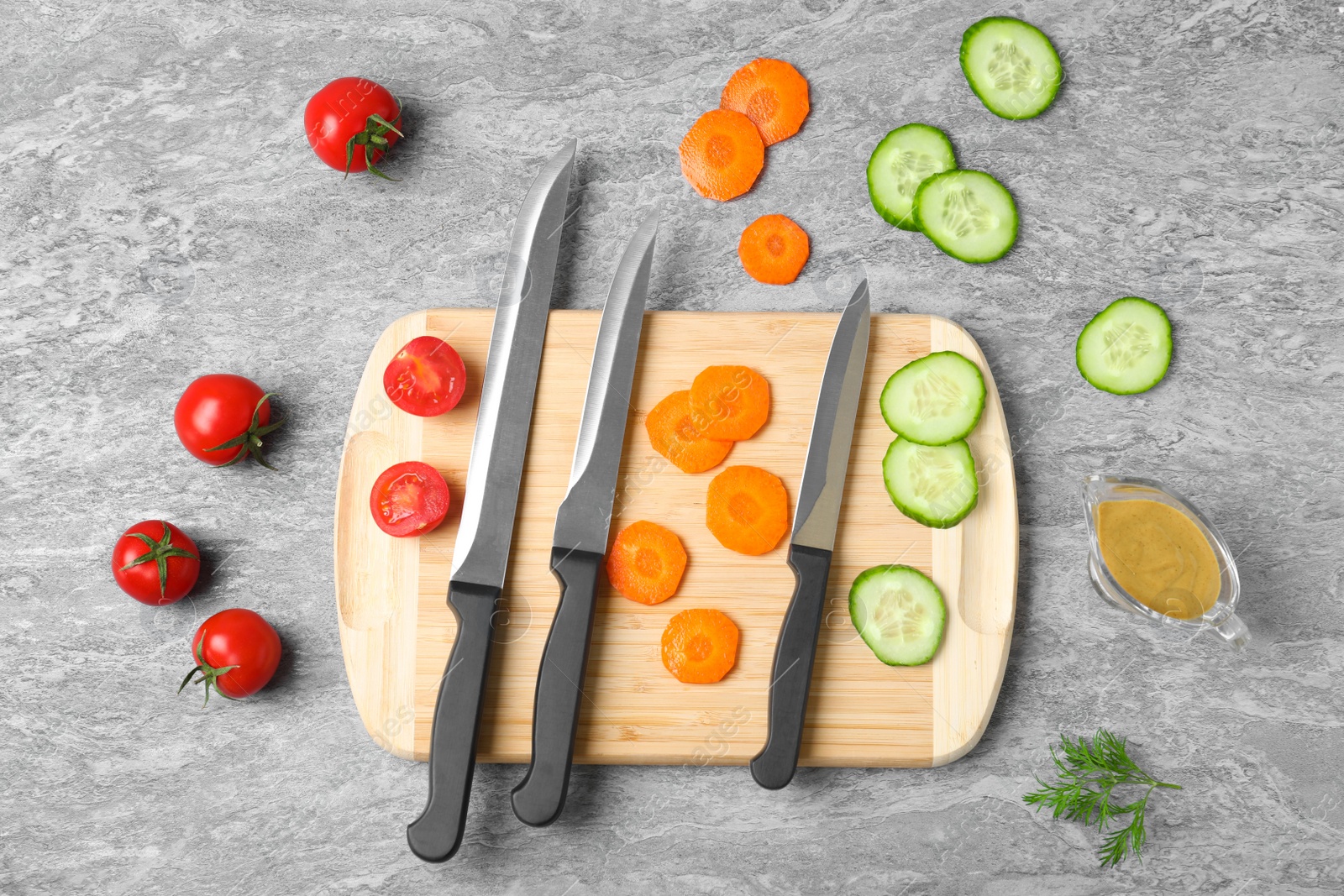 Photo of Flat lay composition with cutting board, knives and vegetables on grey background