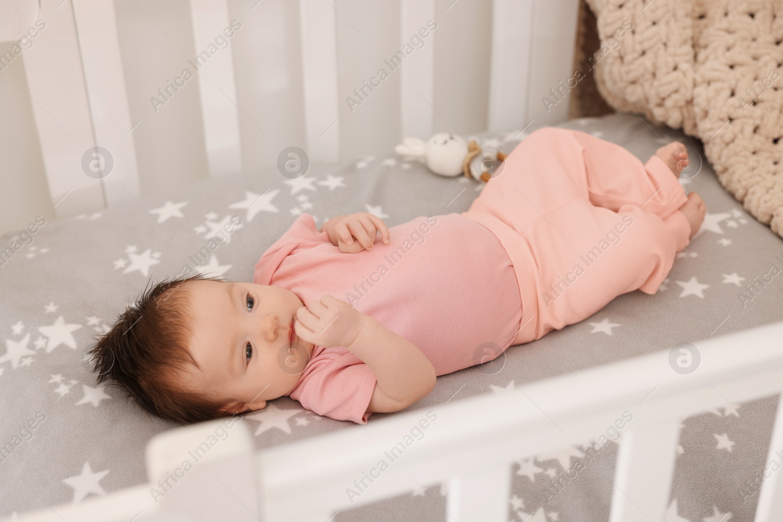 Photo of Getting ready for bed. Cute little baby lying in crib