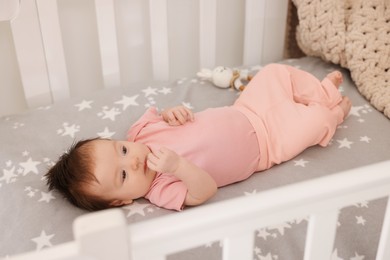 Getting ready for bed. Cute little baby lying in crib