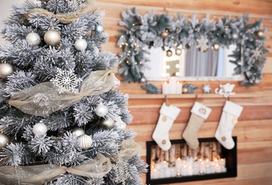 Beautiful decorated Christmas tree near fireplace. Festive interior