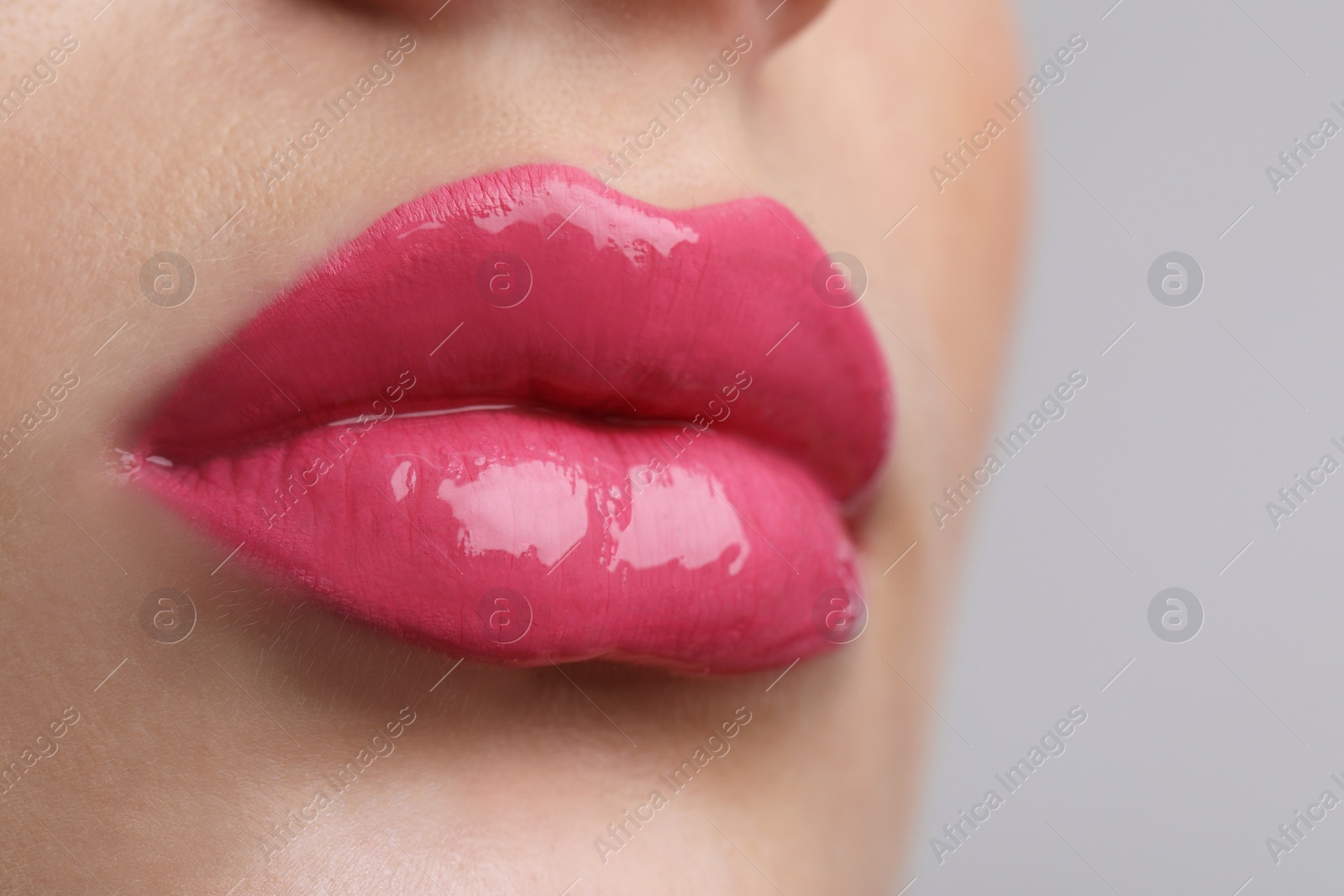 Photo of Closeup view of beautiful young woman with perfect lips makeup on light grey background