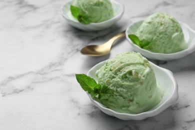 Photo of Delicious pistachio ice cream on marble table. Space for text