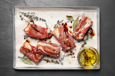 Raw marinated ribs on black table, top view