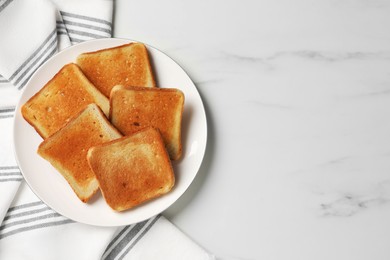 Photo of Slices of tasty toasted bread on white marble table, top view. Space for text
