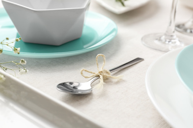 Photo of Spoon with rope on table. Stylish setting