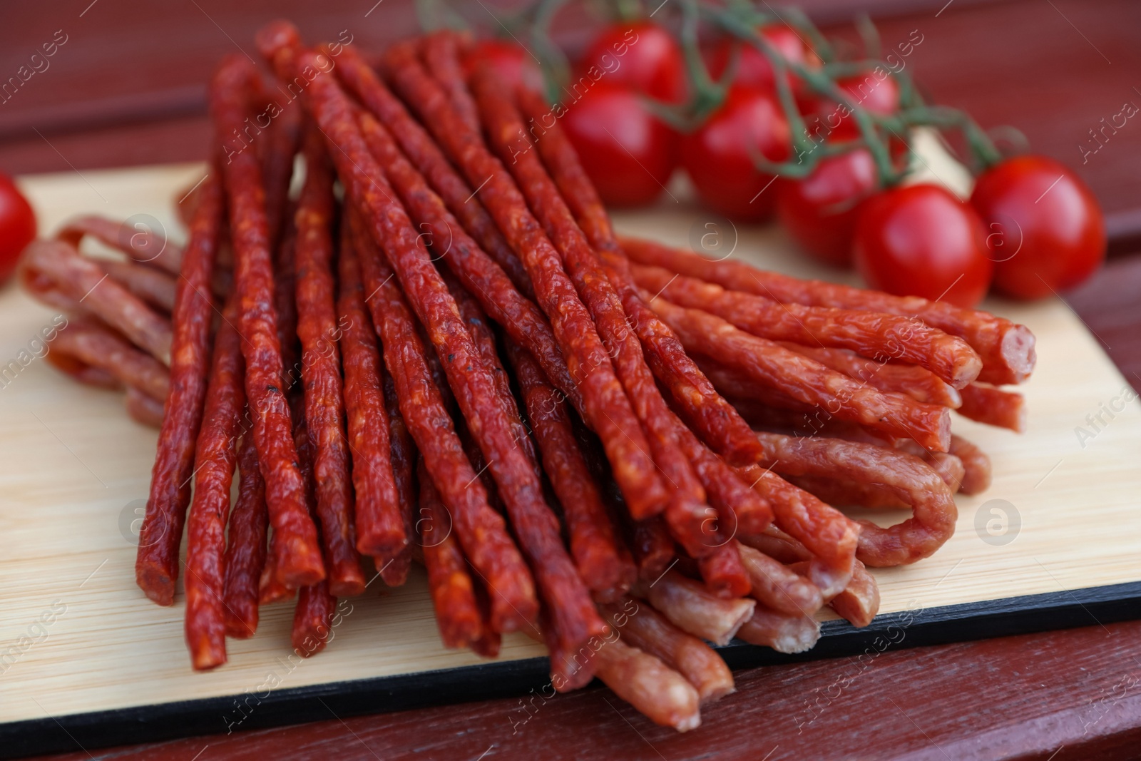 Photo of Tasty dry cured sausages (kabanosy) on wooden table, closeup