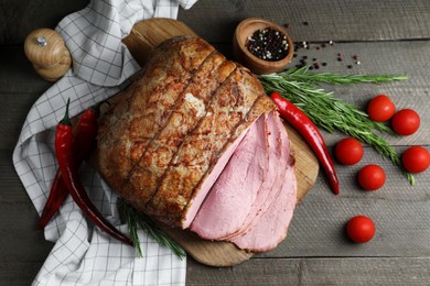 Photo of Delicious baked ham, tomatoes, chili peppers and rosemary on grey wooden table, flat lay