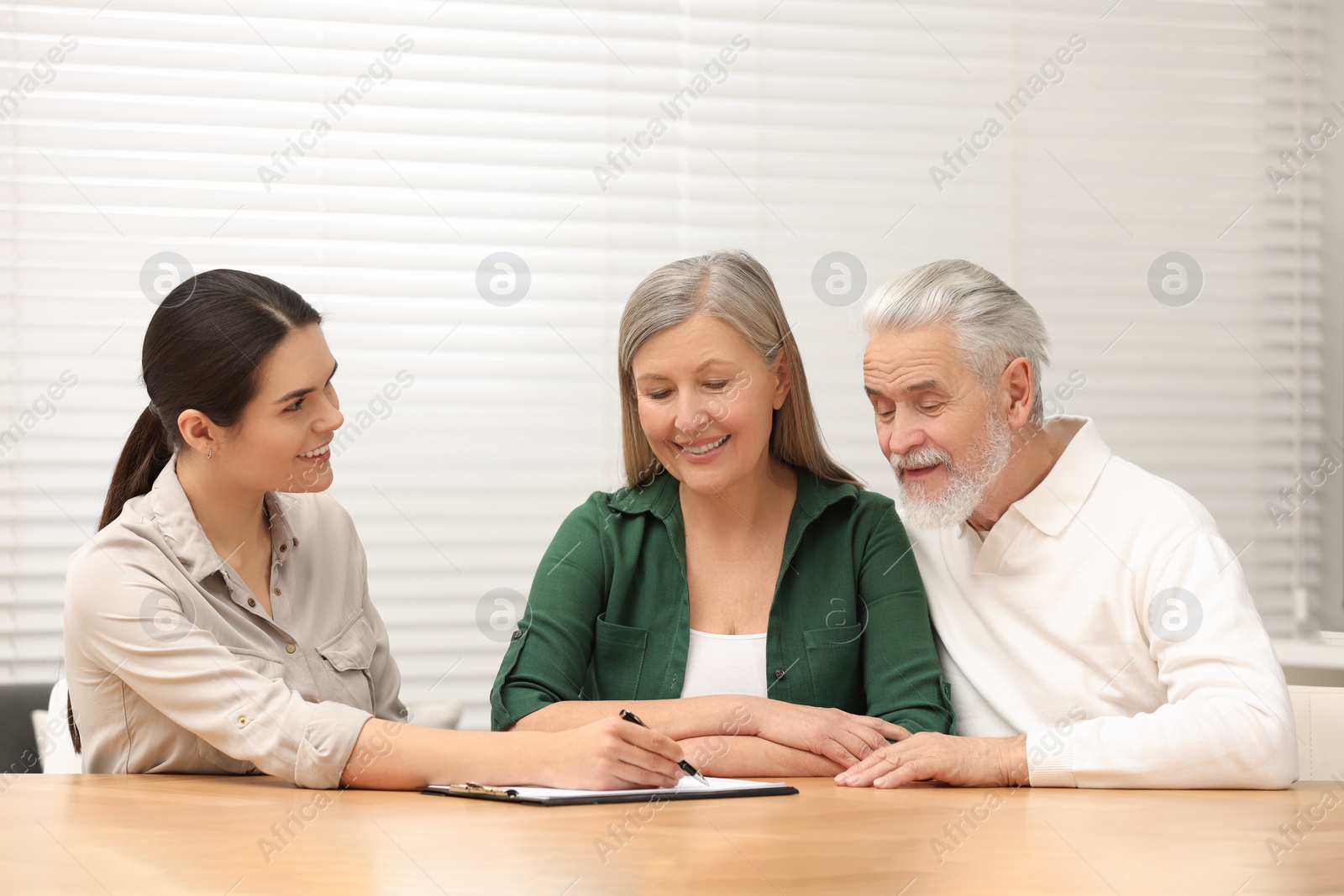 Photo of Notary showing senior couple where to sign Last Will and Testament in office