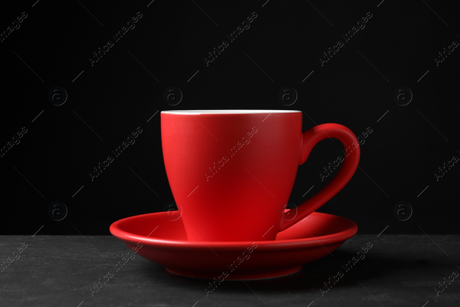 Photo of Red beautiful cup on black textured table