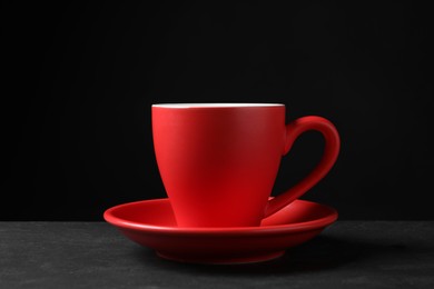 Red beautiful cup on black textured table