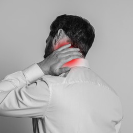 Man suffering from rheumatism on light background. Black and white effect with red accent in painful area