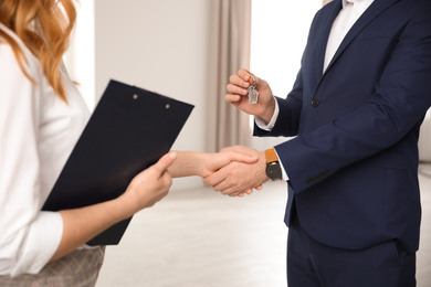 Photo of Real estate agent shaking hands with client in office, closeup