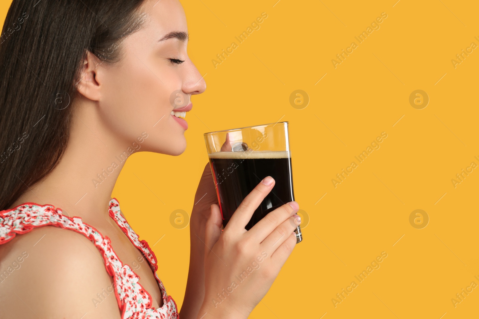 Photo of Beautiful woman with cold kvass on yellow background. Traditional Russian summer drink