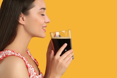 Photo of Beautiful woman with cold kvass on yellow background. Traditional Russian summer drink