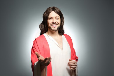 Photo of Jesus Christ reaching out his hand on grey background