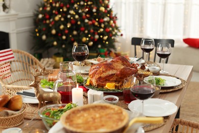 Photo of Festive dinner with delicious baked turkey served on table indoors. Christmas celebration