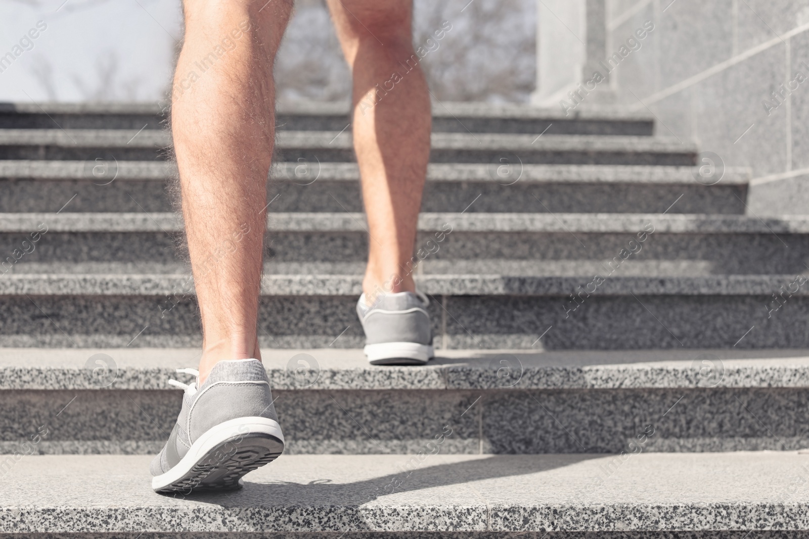 Photo of Sporty young man in training shoes outdoors, closeup