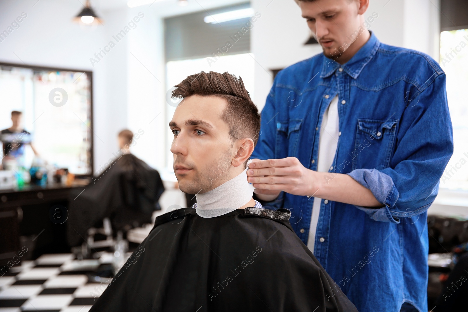 Photo of Professional barber working with client in hairdressing salon. Hipster fashion