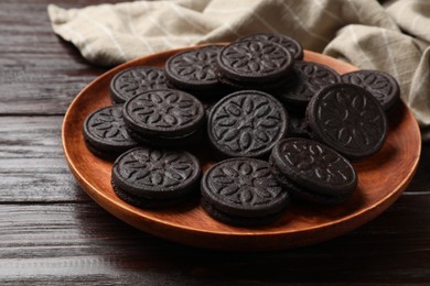 Photo of Plate with tasty sandwich cookies on wooden table, closeup