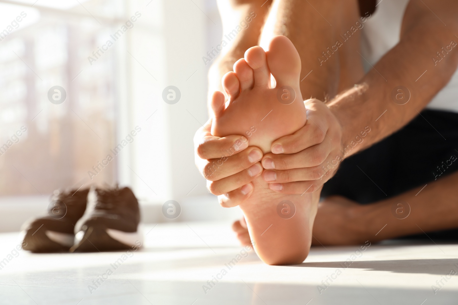 Photo of Man suffering from foot pain indoors, closeup. Space for text