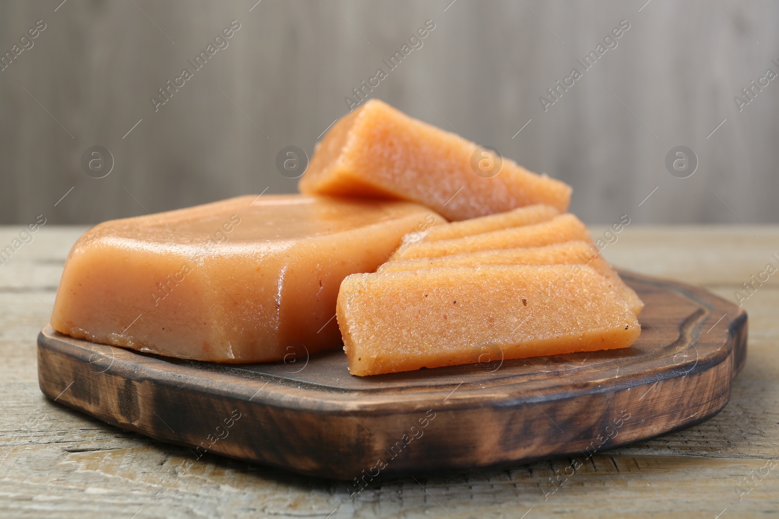 Photo of Tasty sweet quince paste on wooden table, closeup