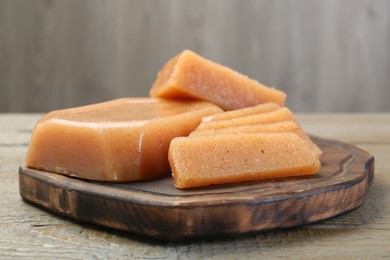 Tasty sweet quince paste on wooden table, closeup