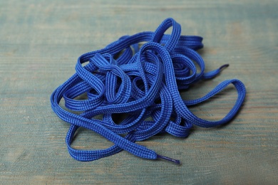 Photo of Shoelaces on light blue wooden background. Stylish accessory