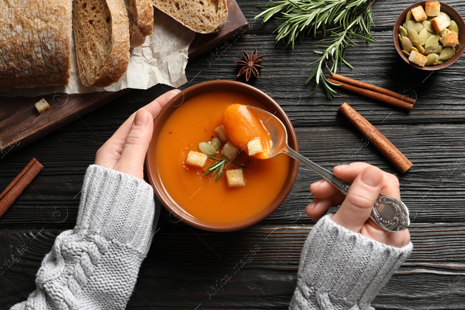 Photo of Woman eating sweet potato soup at table, top view