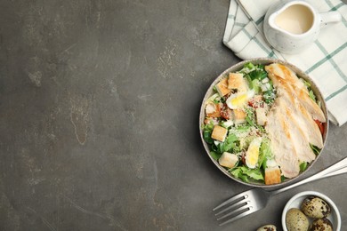 Photo of Delicious Caesar salad in bowl on grey table, flat lay. Space for text