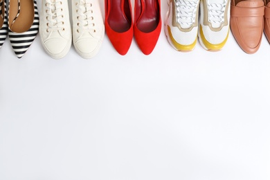 Different shoes on white background, top view