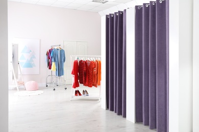 Photo of Fashion store interior with dressing rooms. Modern design