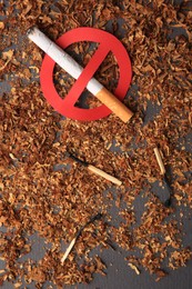 Photo of Cigarette with prohibition sign, burnt matches and dry tobacco on dark grey background, flat lay. Quitting smoking concept