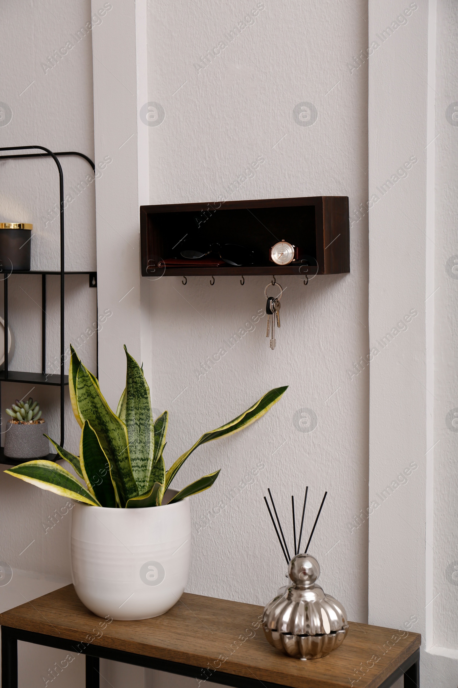 Photo of Stylish hanger for keys on white wall in hallway