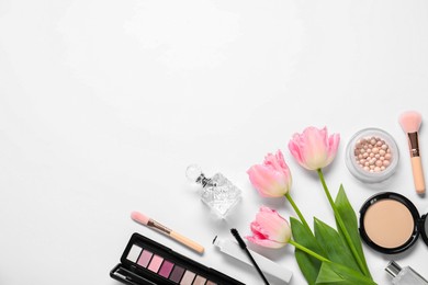 Flat lay composition with different makeup products and beautiful spring flowers on white background, space for text