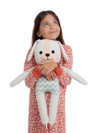 Photo of Cute girl wearing pajamas with toy on white background