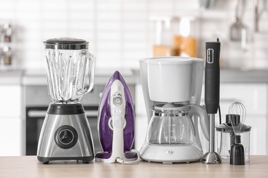 Photo of Household and kitchen appliances on table against blurred background