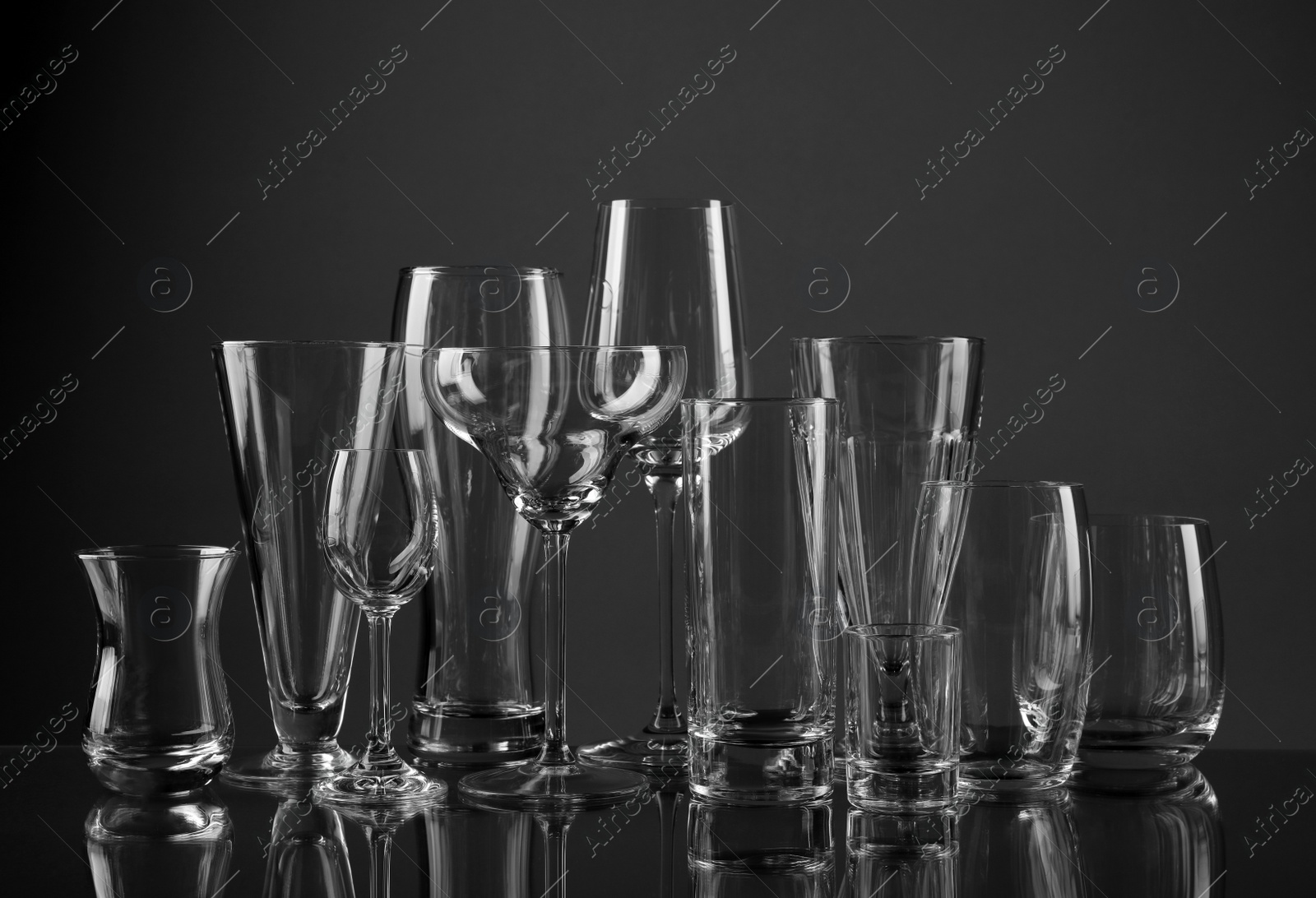 Photo of Empty glasses for different drinks on dark background