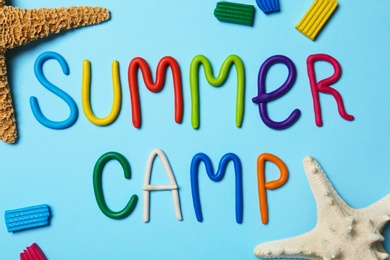 Photo of Flat lay composition with text SUMMER CAMP made of modelling clay on color background