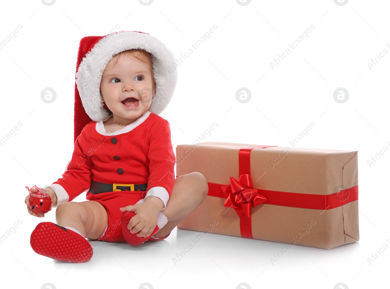 Photo of Cute little baby in Christmas costume and gift on white background